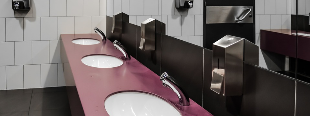 Three sinks and a large mirror within a bathroom